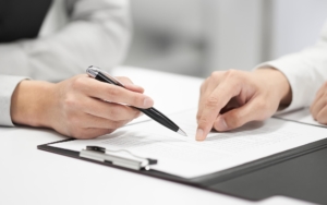 Roof Warranty papers being looked over and signed June Blog 2